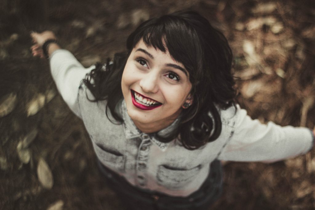 mujer sonriendo con los brazos abiertos