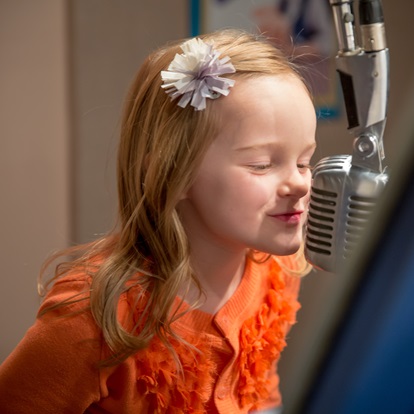 niña grabando un programa de radio