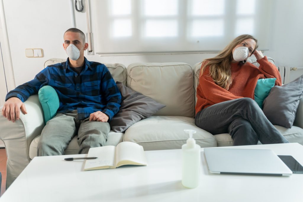 Hombre y mujer en un sillon con mascarilla