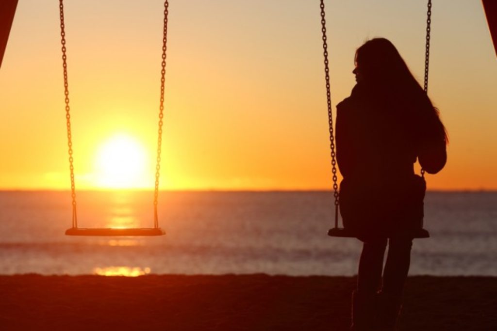 mujer sentada viendo un atardecer