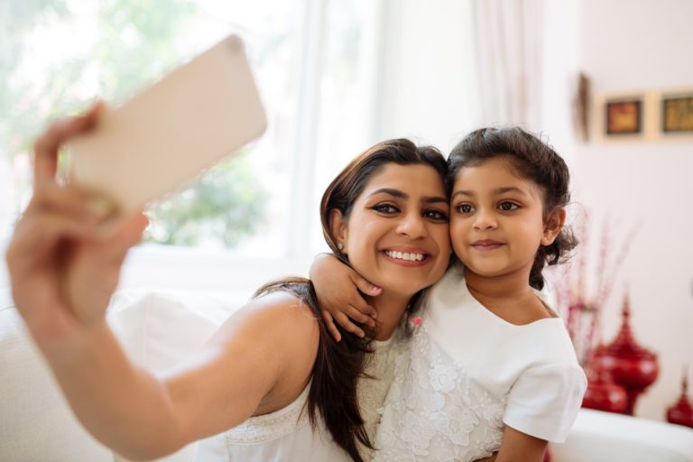 madre e hija tomandose un selfie en la sala