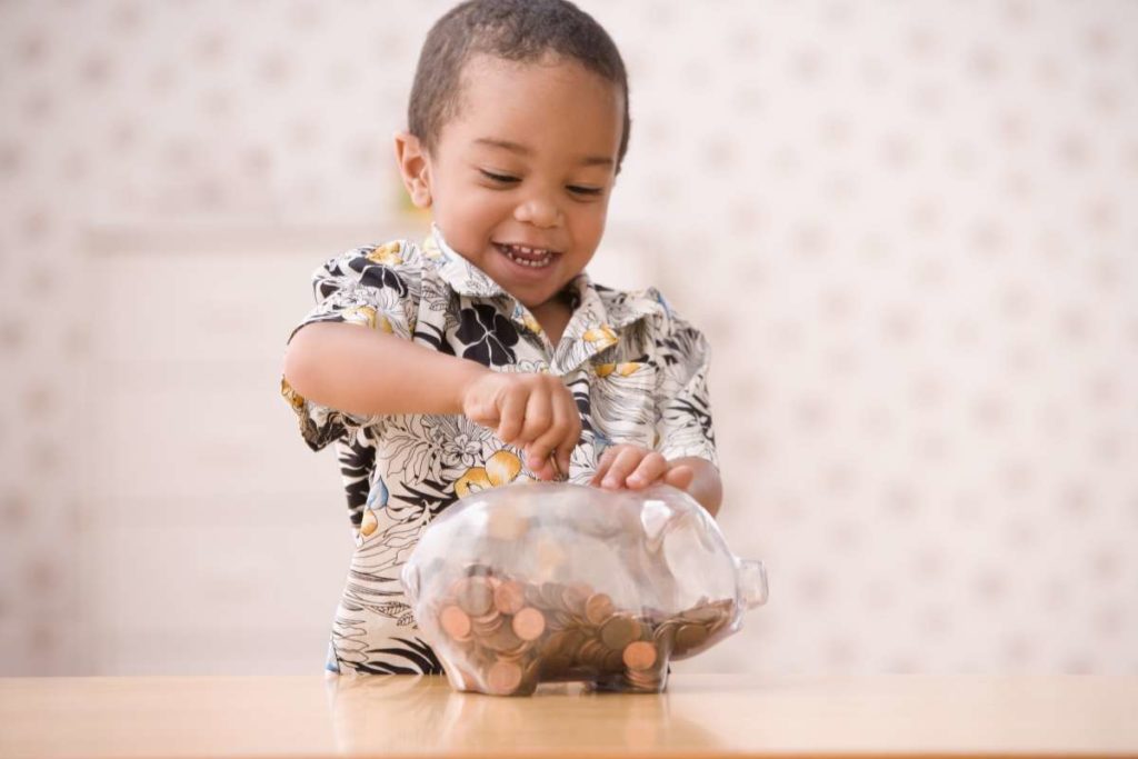 niño metiendo una moneda a una alcancia