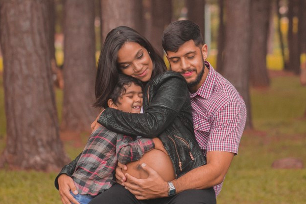 Madre embarazada y esposo e hijo abrazandola