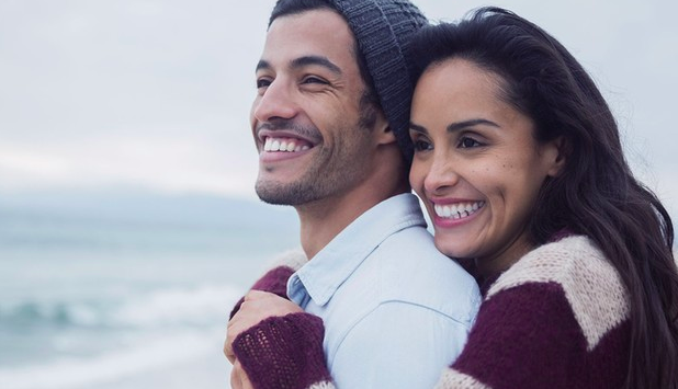 Mujer y hombre abrazados viendo el mar