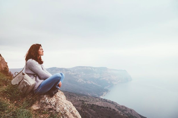 Mujer viendo un paisaje en unas montañas