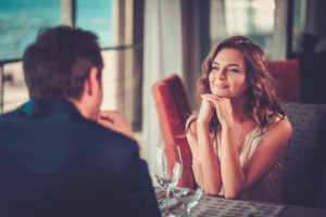Mujer sonriente en una cena romantica con un hombre
