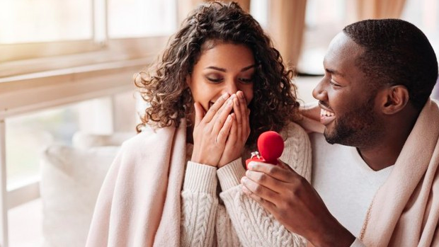 Hombre enseñando un anillo a su novia