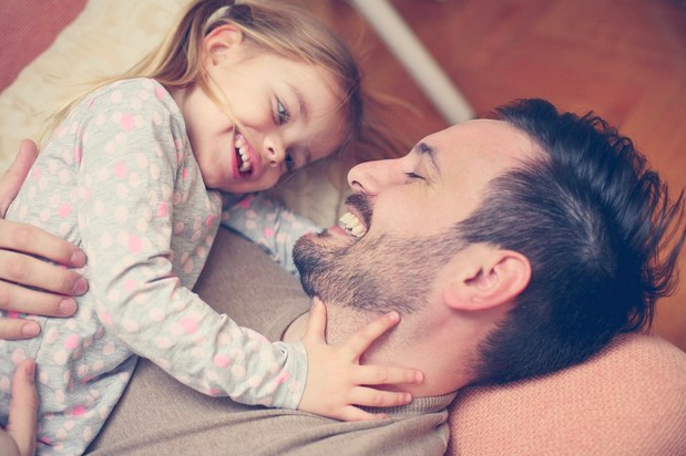 Padre con su hija en brazos sonriendo