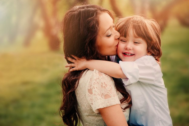 Mamá joven besando a su hijo pequeño