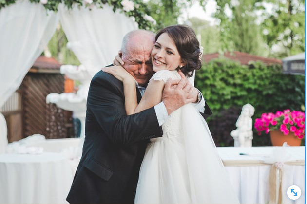 Mujer con vestido de novia y su padre mayor abrazandola lloroso