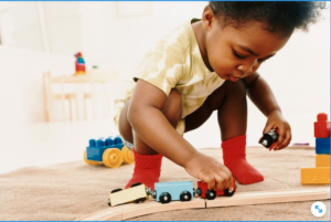 Niño pequeño jugando con un tren de madera