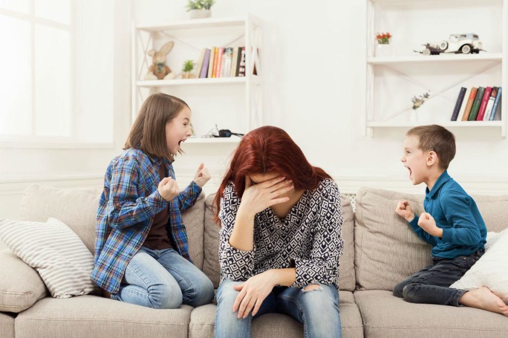 niños gritando y su madre estresada