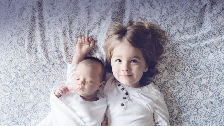 niña junto a su hermano bebe