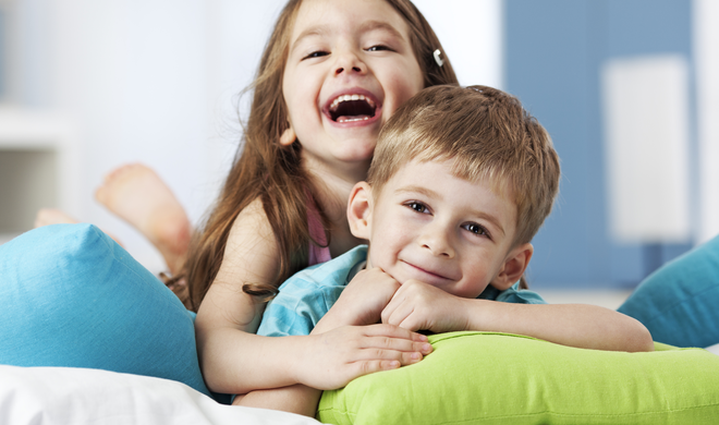 niña y niño riendole a la camara