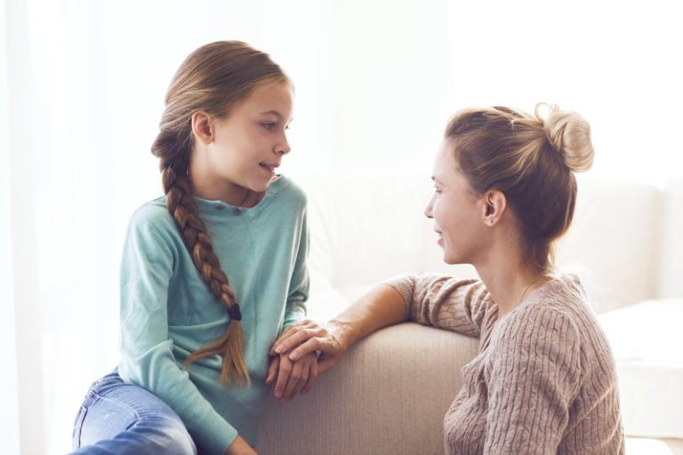 Niña hablando con su mamá en un sofa