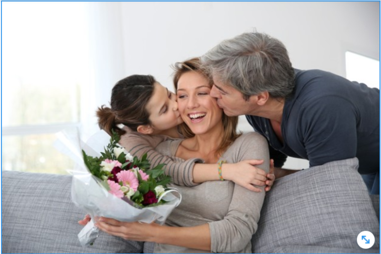 Esposo e hija dandole un ramo de flores a la madre