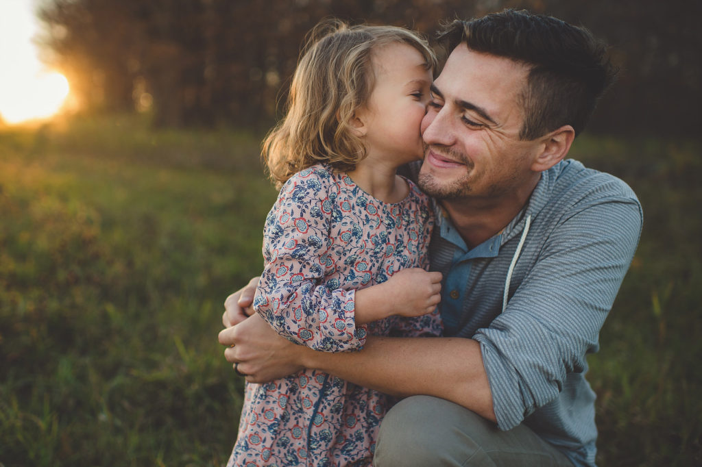 niña pequeña rubia besando a su papá