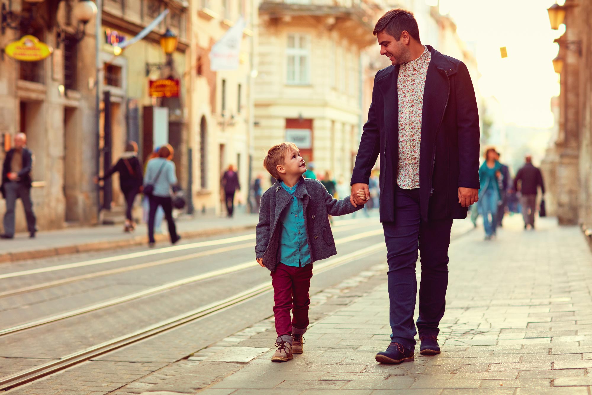 Папа с сыном поехали. Мужчина с ребенком за руку. Дети на прогулке. Мужчина с ребенком на улице. Прогулка в городе.