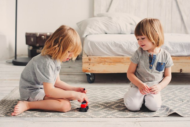 niños jugando con carros en la sala