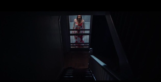 Mujer en el piso debajo de unas escaleras