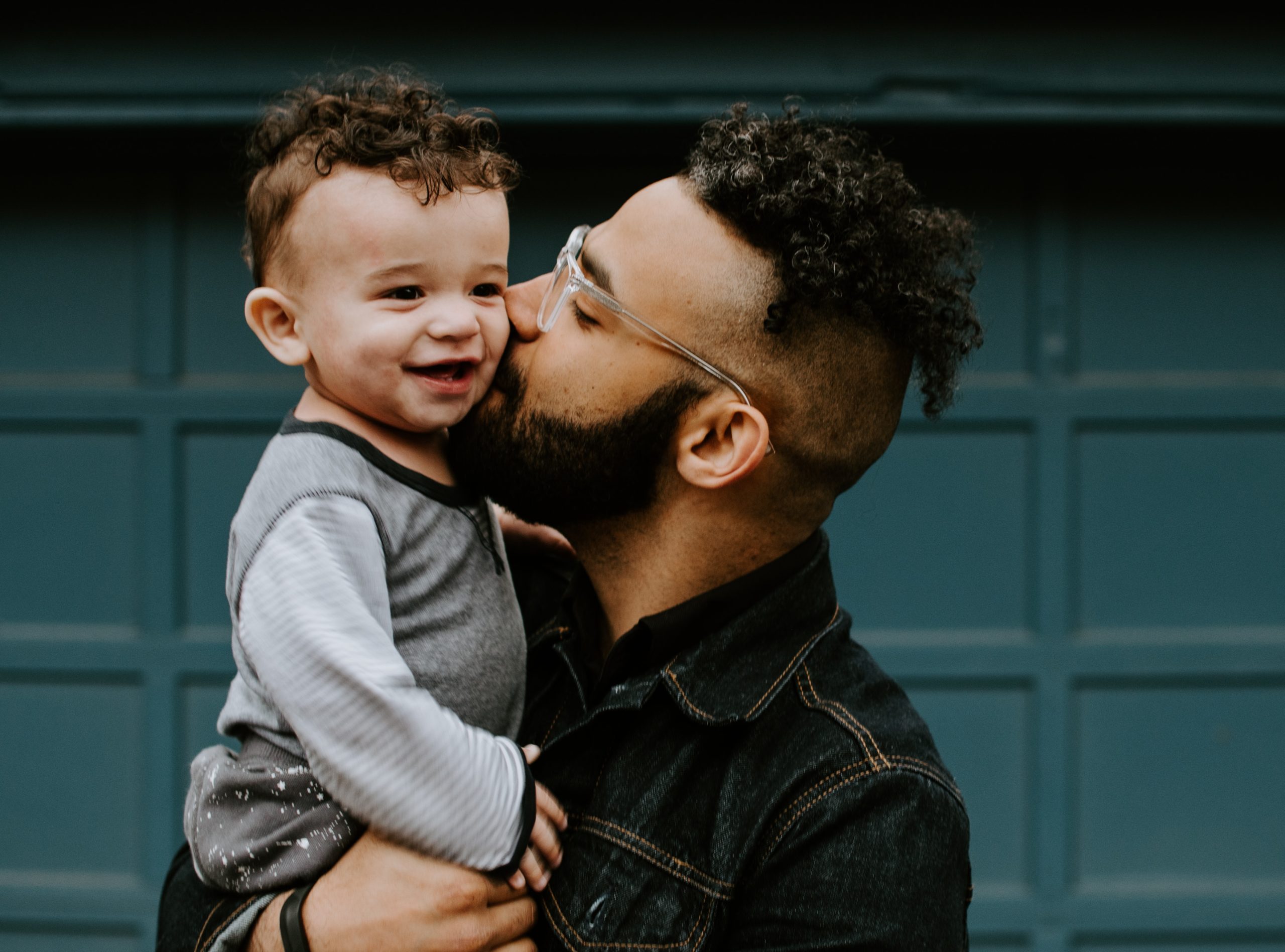 Hombre dandole un beso a su hijo bebé