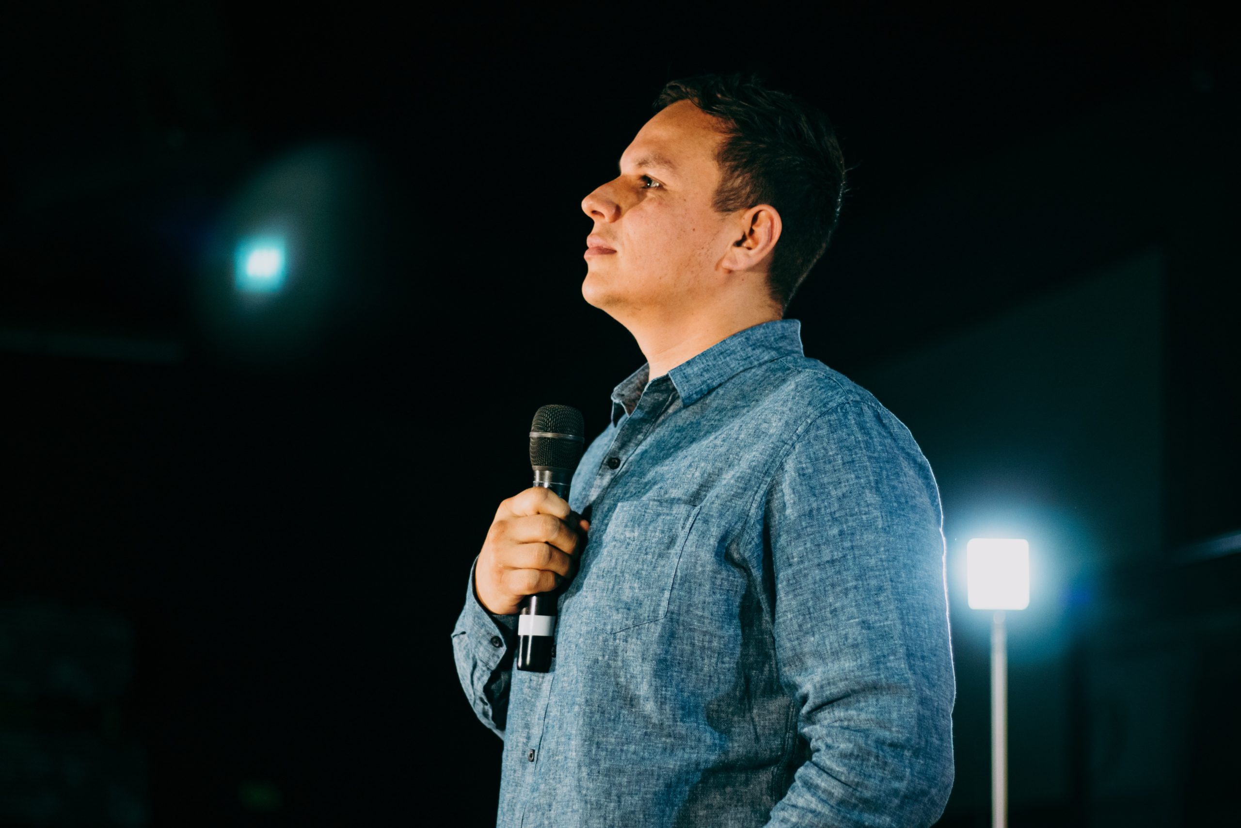 Pastor con un microfono en una tarima