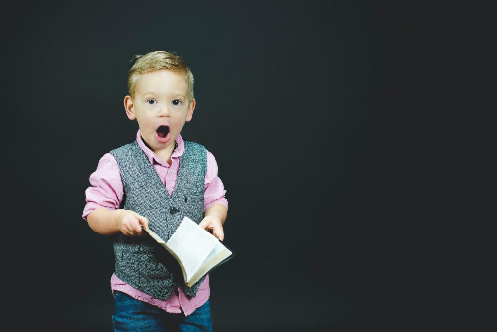 Niño somprendido con una biblia en sus manos