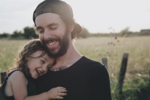 Hija abrazando a su papá y sonriendo