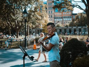 hombre tocando un violin en un parque