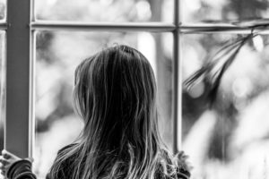 Foto en blanco y negro de Adolescente viendo por una ventana
