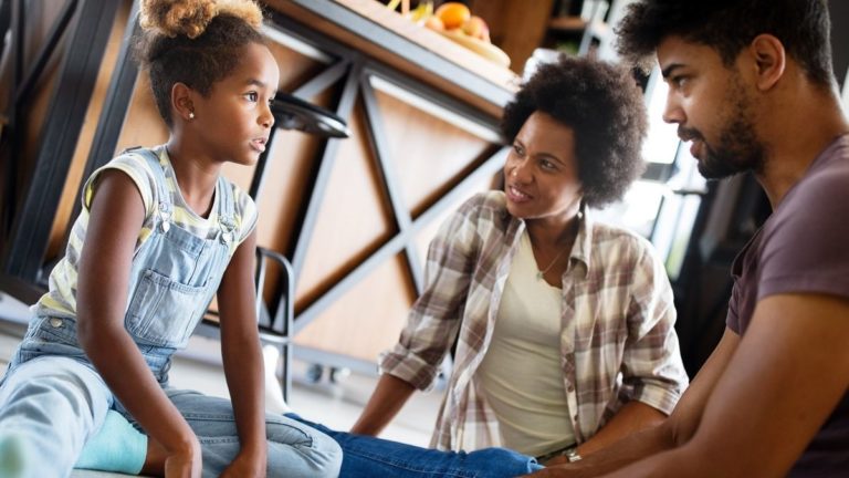 Mujer sonriente viendo a su hija en la sala