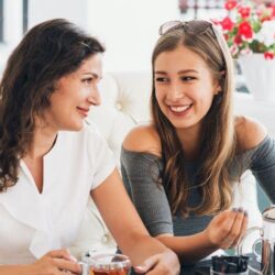 Madre e hija tomando té en un sofa