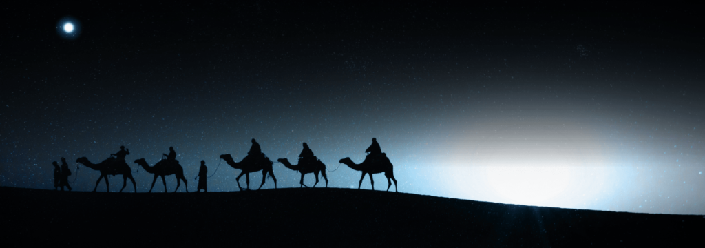 Siluetas de camellos y personas caminando por el desierto de noche con la luz de la luna