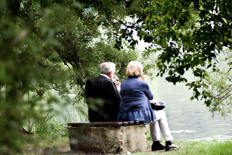 Ancianos en un banco viendo un lago