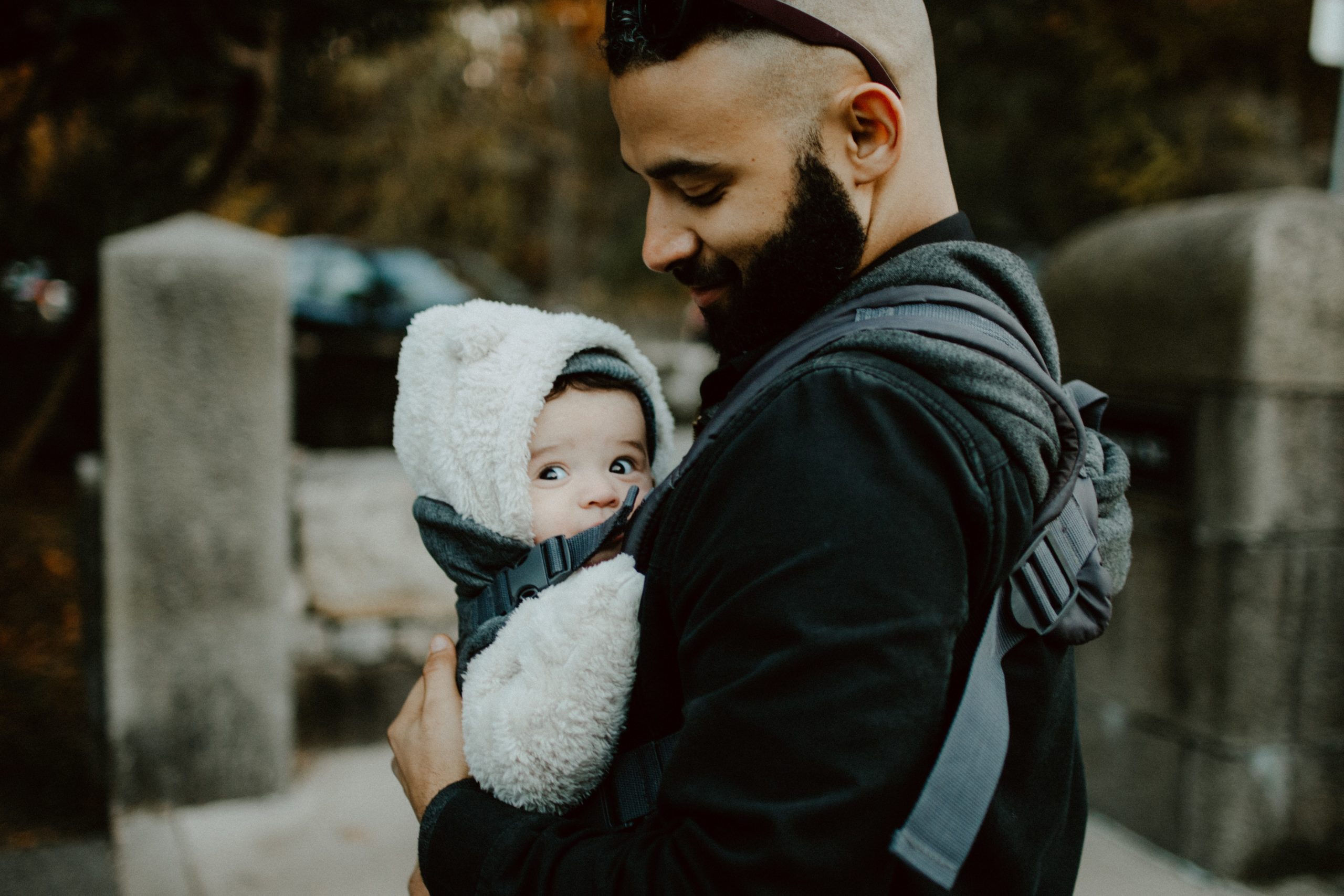 Papa con anteojos con su hijo en brazos