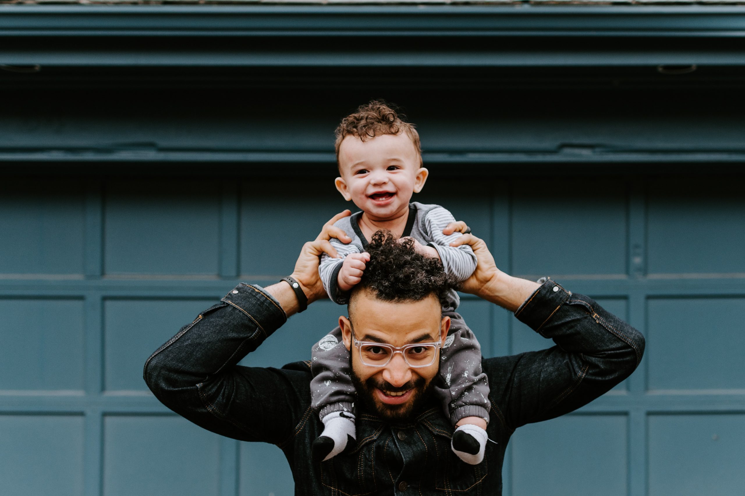 Papa sonriendo con su hijos en brazos riendo