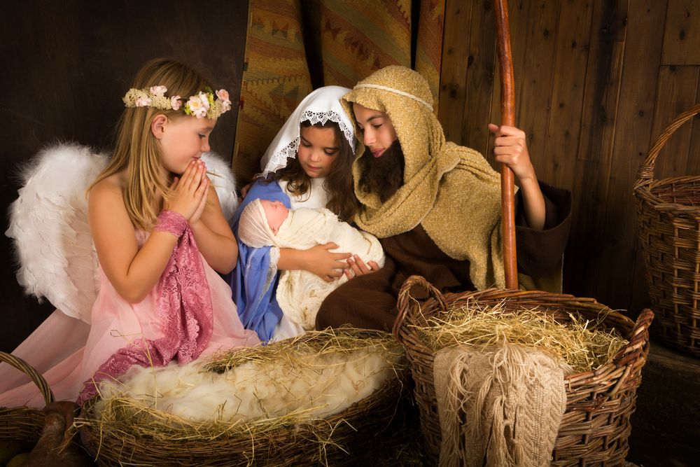 Representación de niñas del pesebre vestidas de maria, un angel y jose