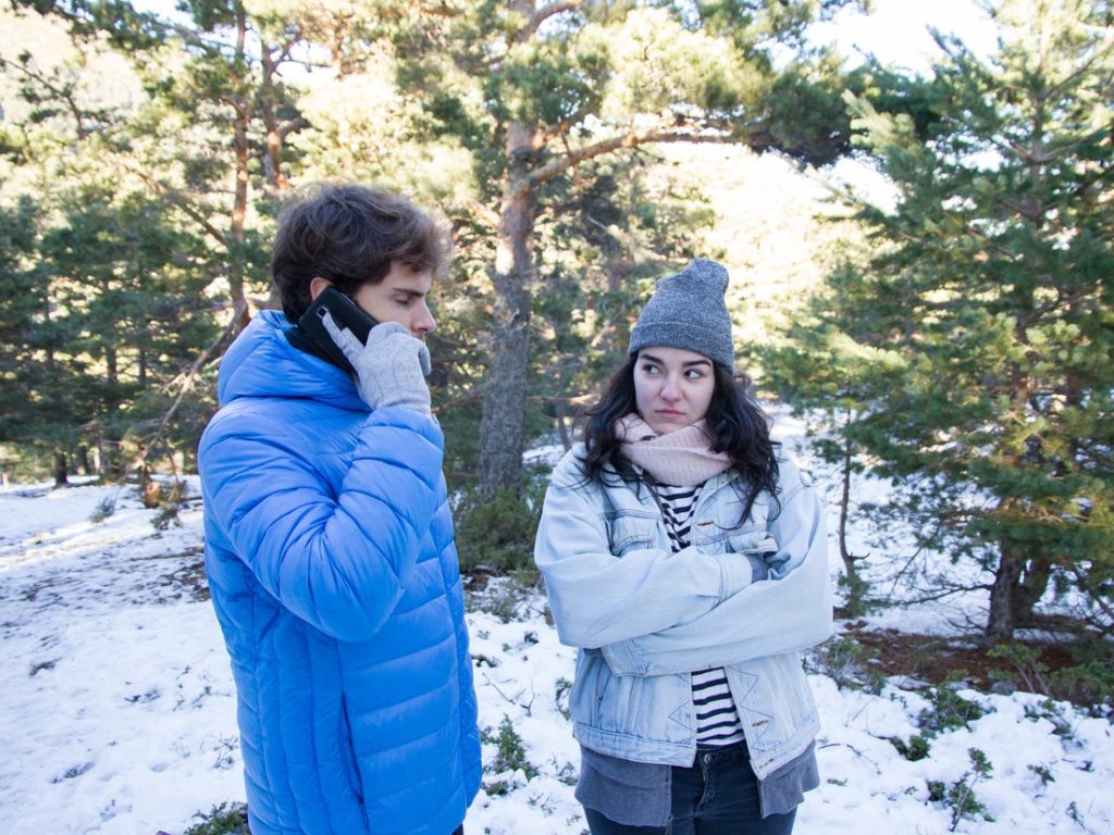 Novia viendo con tensión a su novio que esa el telefono