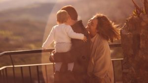 Padre con hiaj en brazos y madre sonriendole a su hija