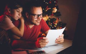 Padre e hija juntos leyendo la lista de deseos de Navidad