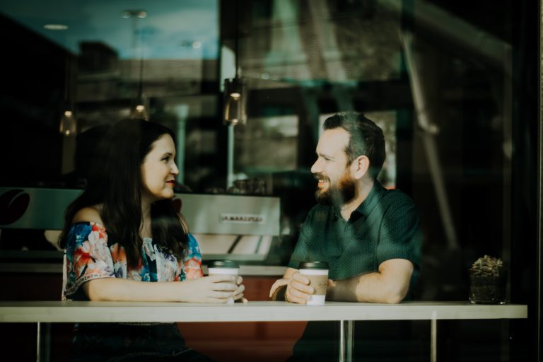 Dos personas en una cafetería tomando cafe y charlando