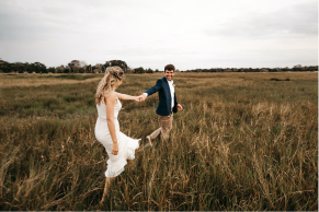 Pareja de esposos caminando en un campo sostenido de las manos y viendose a los ojos