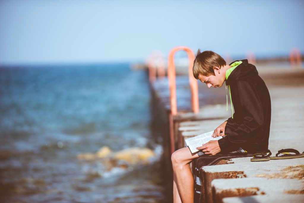 Hombre en un bahía leyendo la bilbia