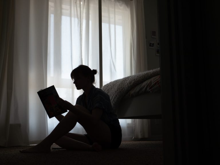 Mujer en un cuarto oscuro Leyendo un libro