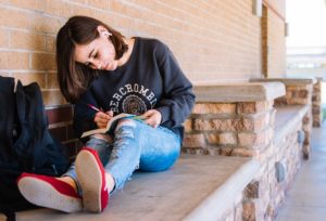 Mujer joven sentada escribiendo