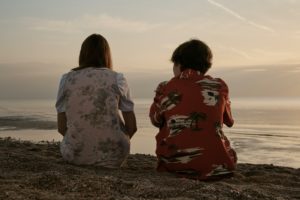 Mujer e hijo sentados en la playa