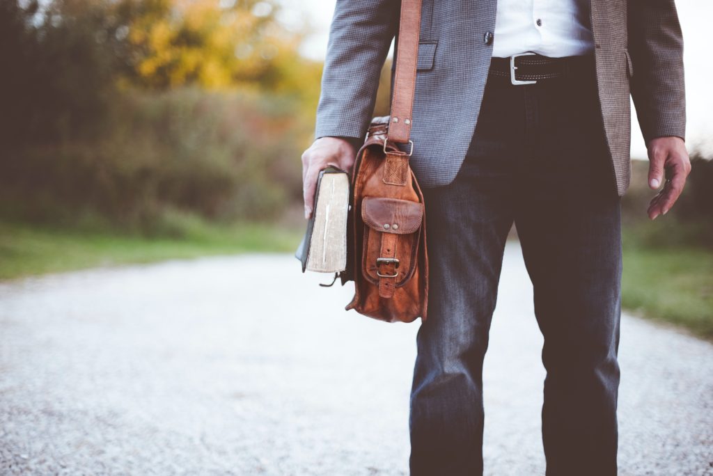 Hombre en un camino con una biblia en las manos