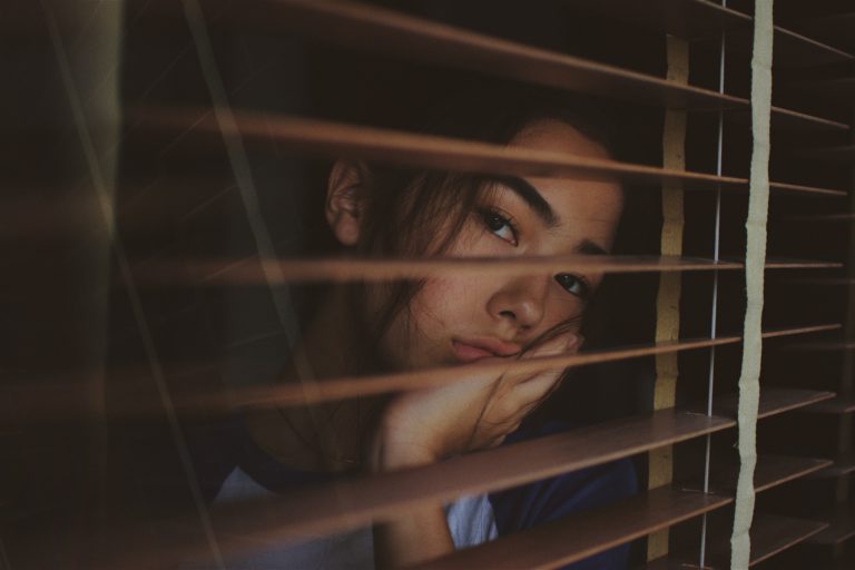 Mujer pensativa viendo por unas ventanas