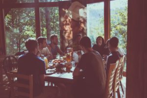 Jovenes en una cabaña en el bosque comiendo