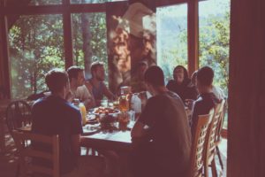 Jovenes en una cabaña en el bosque comiendo